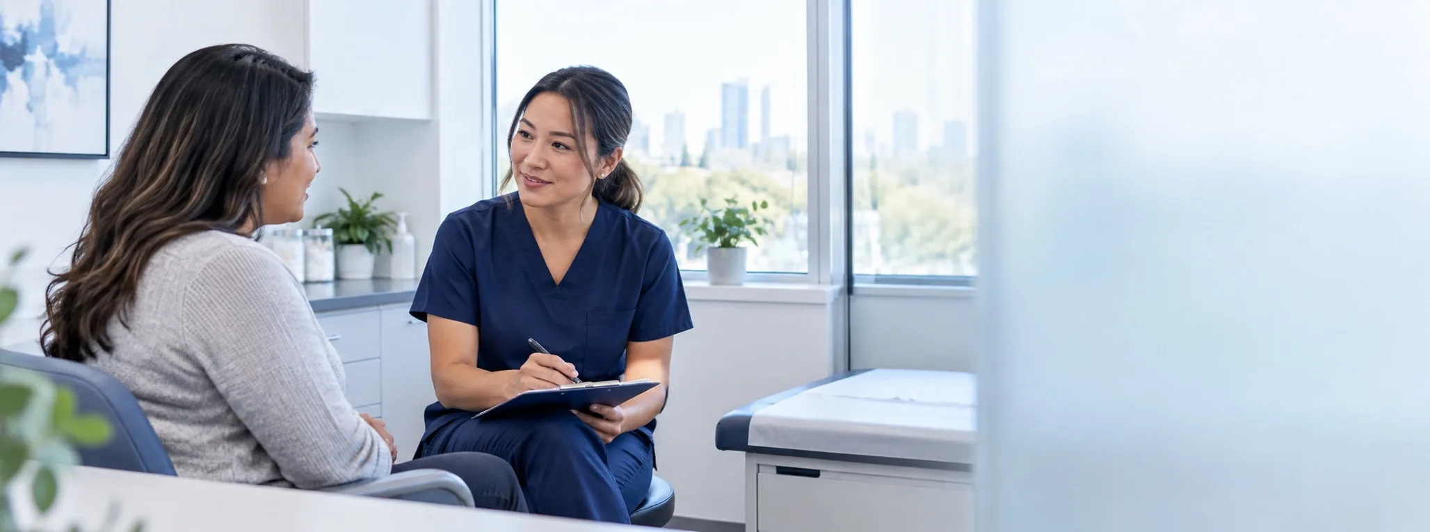 A clinician speaking with a patient in a bright medical exam room